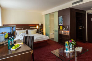 Ein Hotelzimmer im Hotel Drees in Dortmund mit Blick auf Schreibtisch, Couchtisch, Bett und Bad